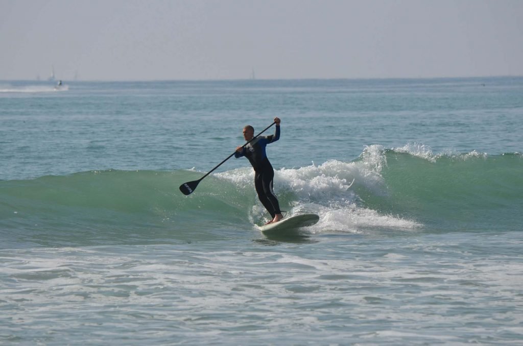 Un hombre surfeando olas en tabla de Paddle Surf