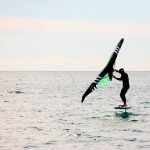 Un hombre esta practicando wingfoil en el mar con una tabla con foil